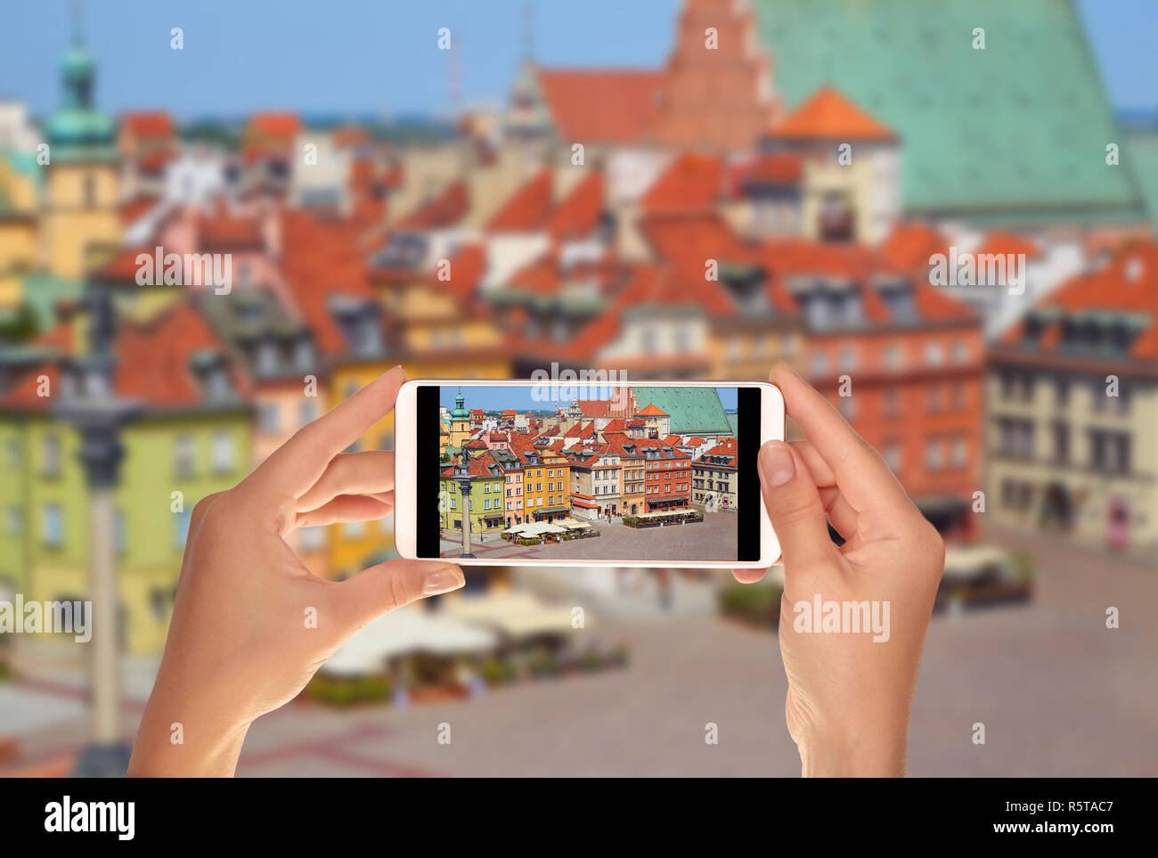 Un turista è scattare una foto della piazza principale della città vecchia a Varsavia in Polonia senza persone su un telefono cellulare Foto Stock