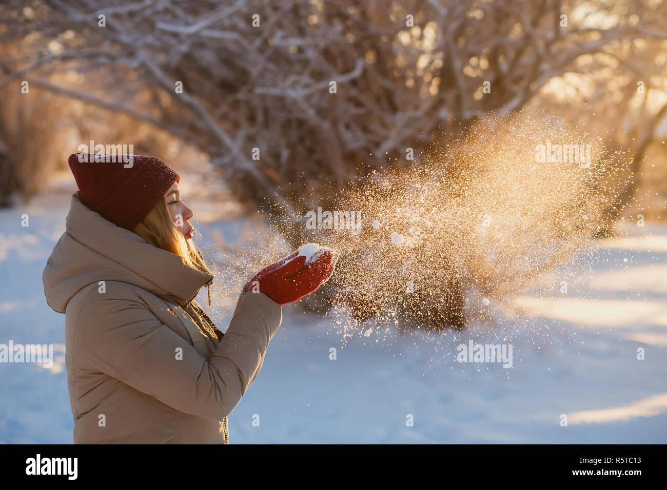 Una donna con occhiali da sole su neve soffiata nelle sue mani . Foto di  alta qualità Foto stock - Alamy