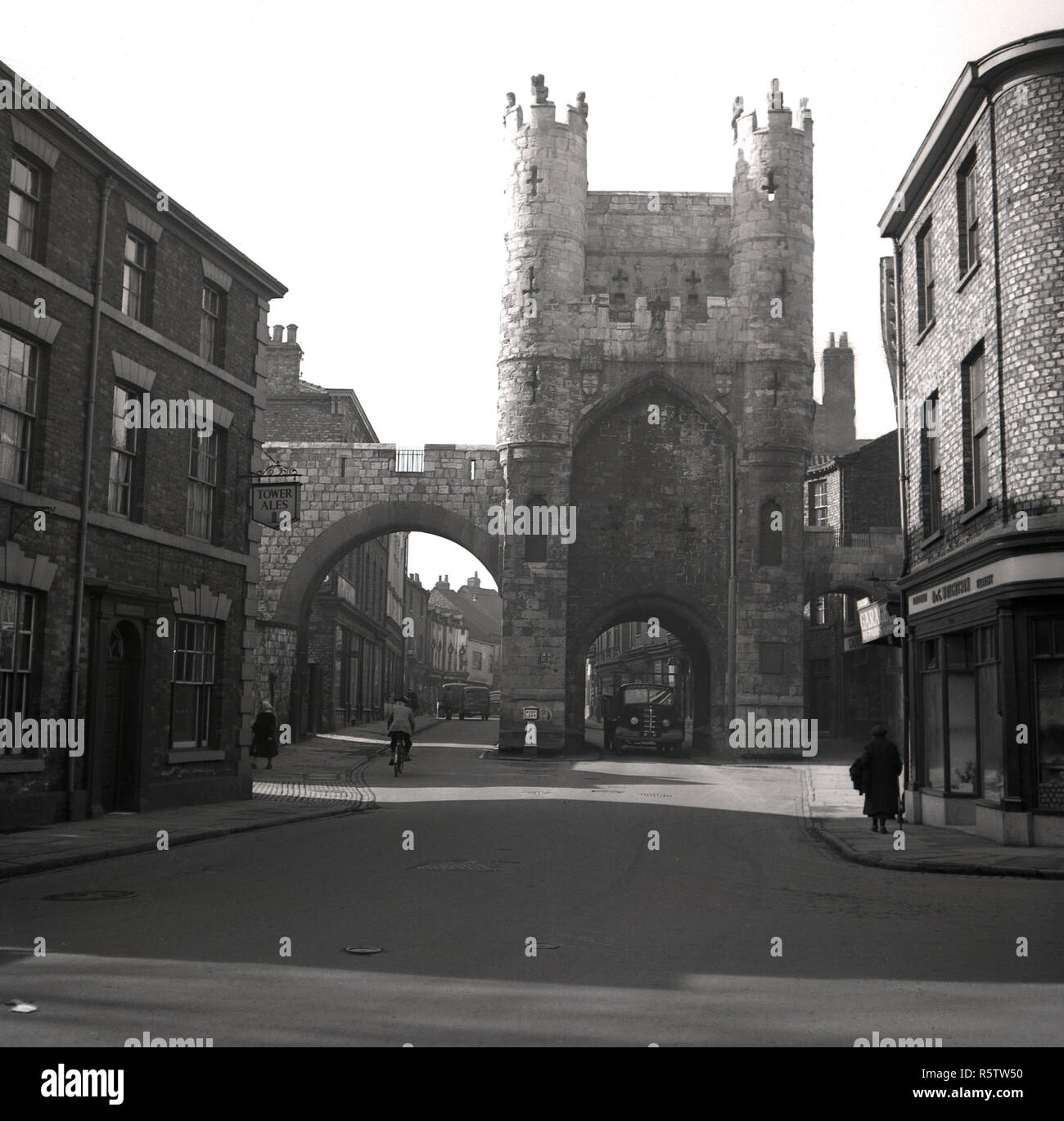 Degli anni Cinquanta, storico, torre medievale e antiche porte, York, Inghilterra, con un segno per la torre Ales su un edificio sulla sinistra dell'immagine. Foto Stock