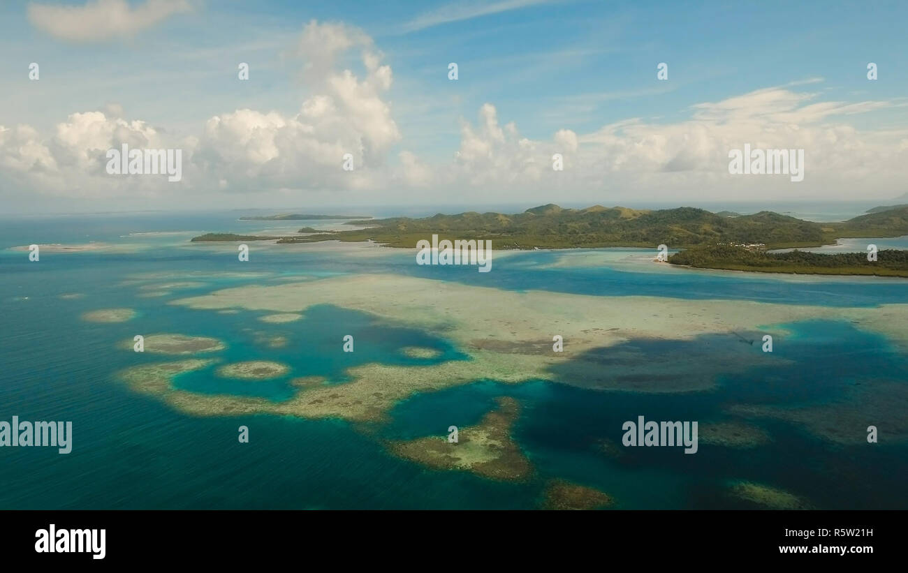 Vista aerea: spiaggia, isola tropicale, Baia Mare e laguna, Siargao. Paesaggio tropicale hill, nuvole e montagne rocce con la foresta pluviale. Acque azzurre della laguna. Paesaggio Shore Bay. Video dell'antenna.Seascape. Foto Stock