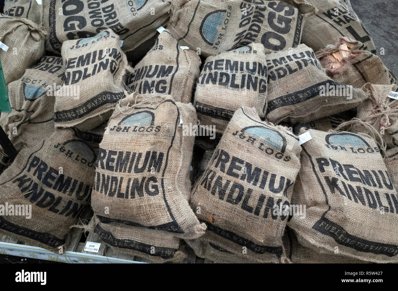 Pezzi di legno fornite in bundle con Hessian sacchi per la vendita in un giardino centrale. Foto Stock