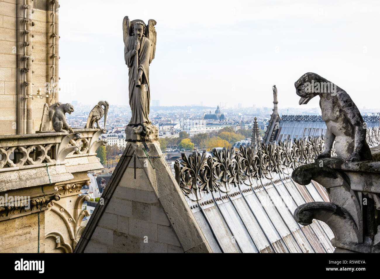 Statue di pietra di chimere che si affaccia sulla terrazza sul tetto della cattedrale di Notre Dame de Paris cathedral dalle torri galleria con la statua di un angelo con tromba un Foto Stock
