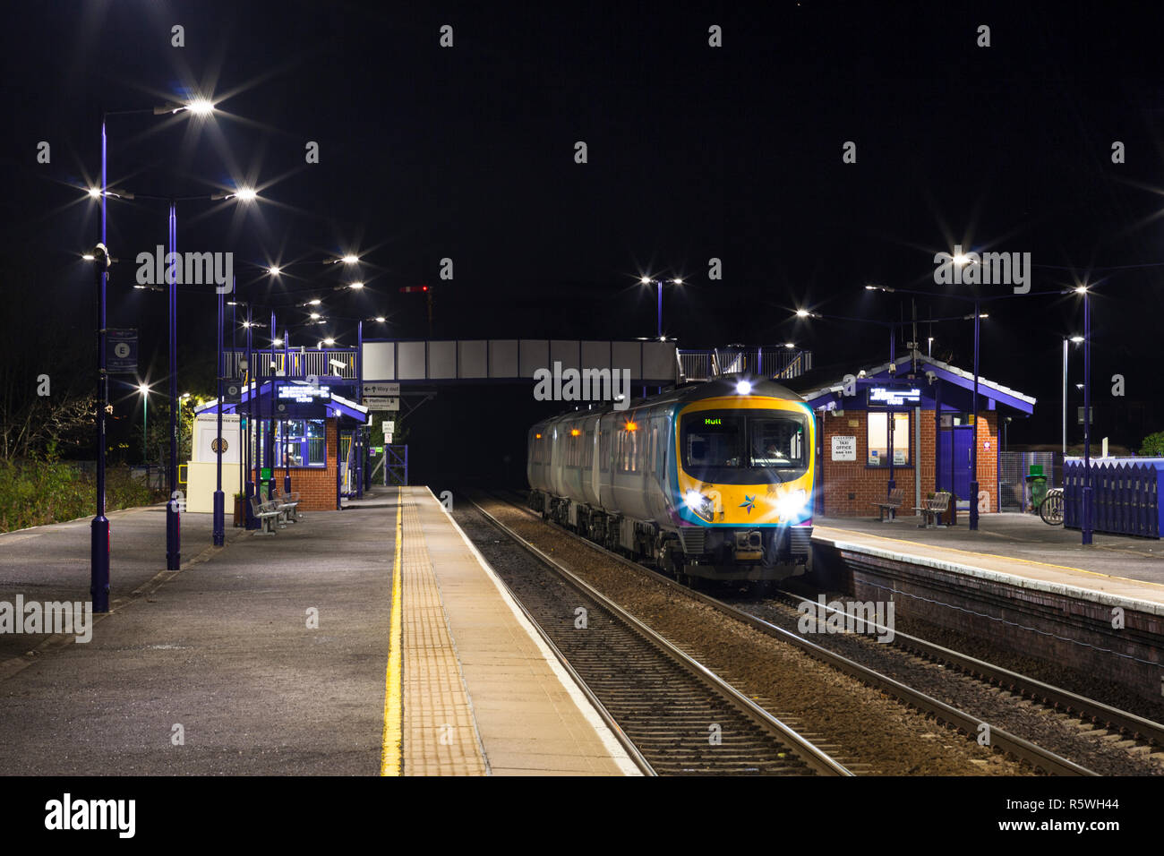 Primo Transpennine Express classe 185 185142 DMU chiamate presso Brough stazione ferroviaria in una notte buia Foto Stock