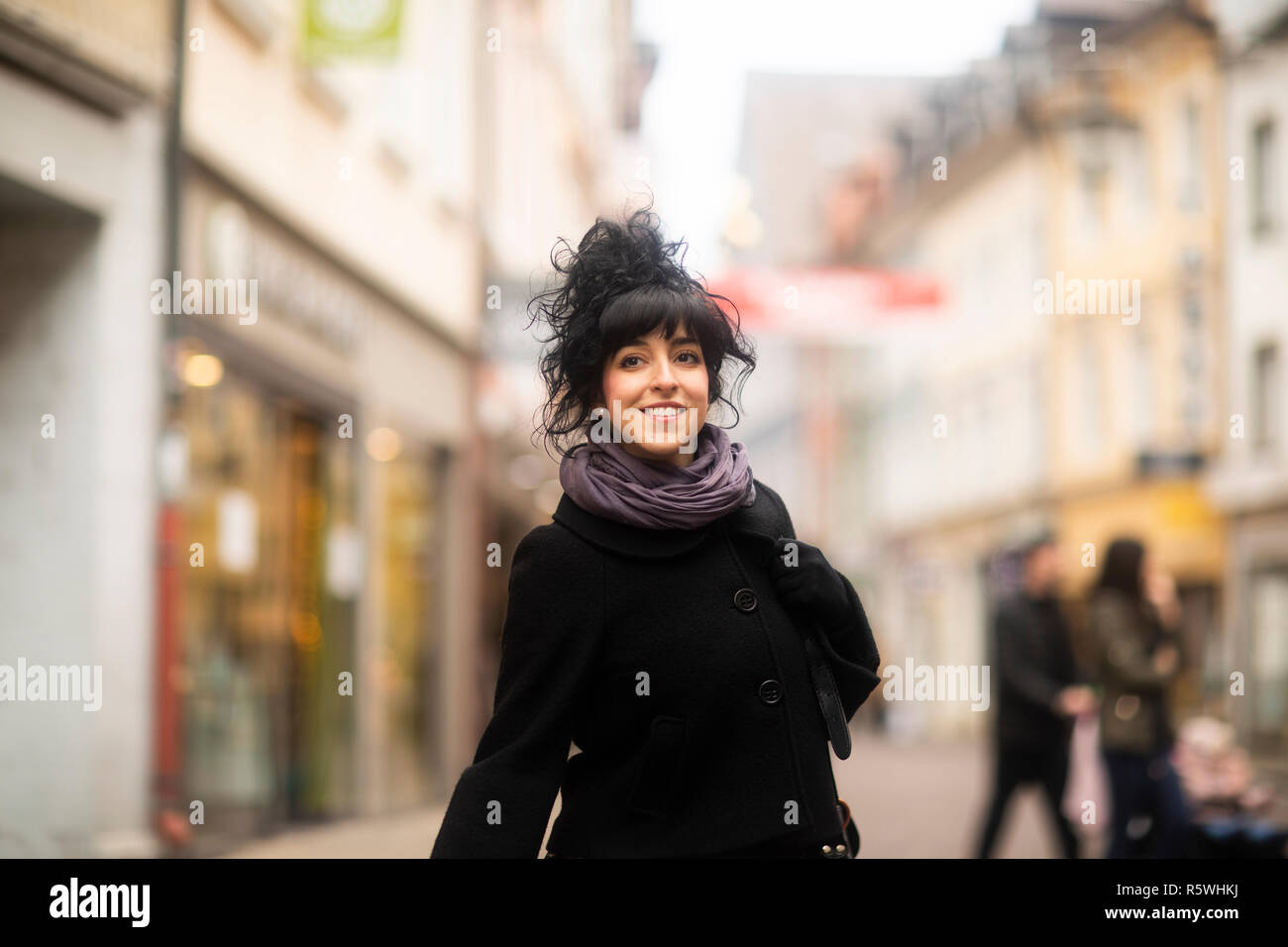 Donna in piedi in una strada di città, Germania Foto Stock