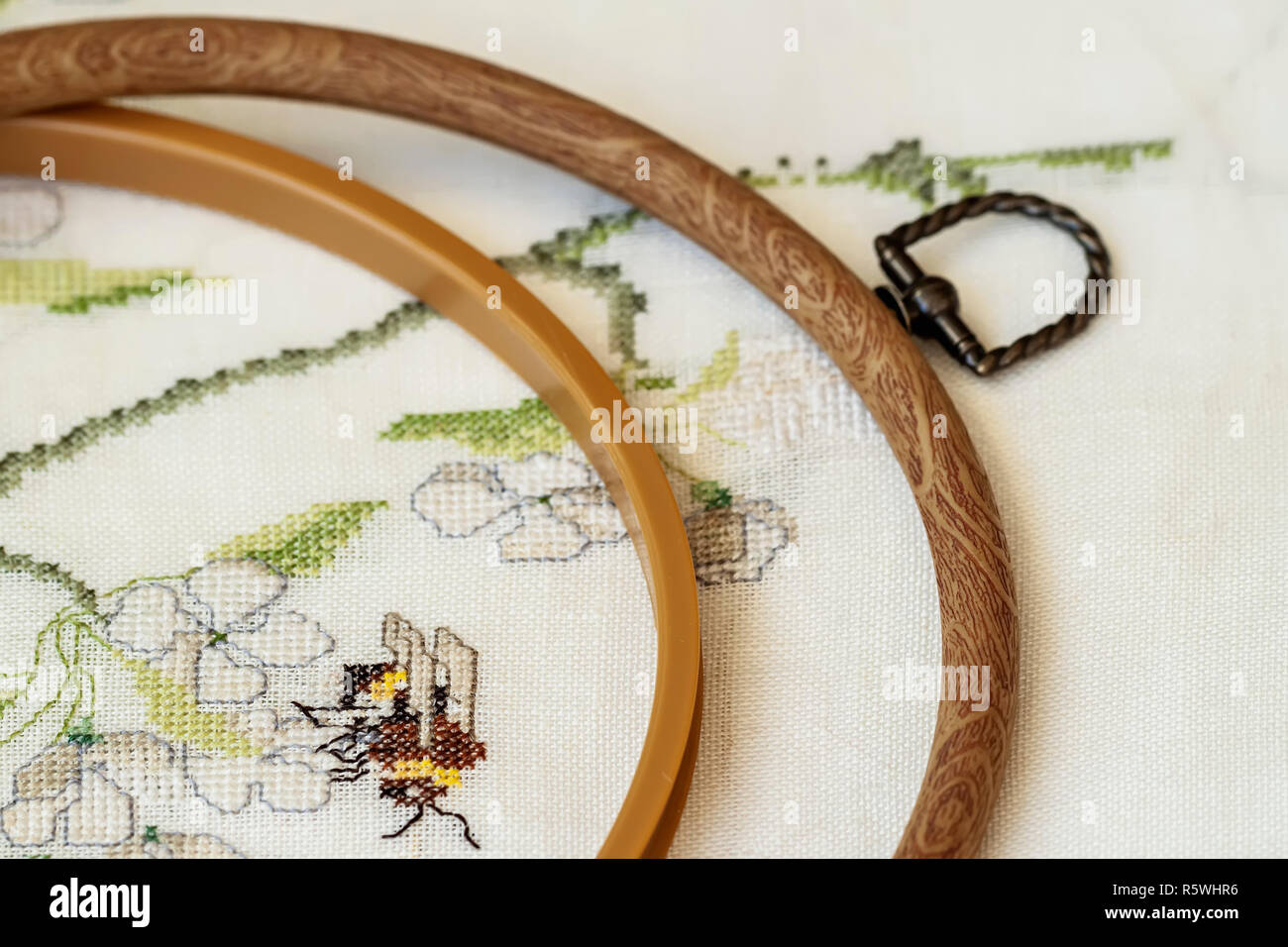 Cerchio da ricamo di legno con frammento di colorati i ricami a punto croce  close-up, estate fregio floreale Foto stock - Alamy
