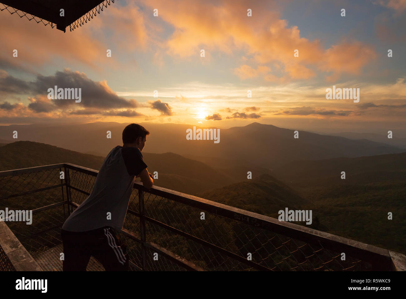 Ragazzo che guarda alla lontana Smoky mountains al tramonto in Asheville, Carolina del Nord Foto Stock