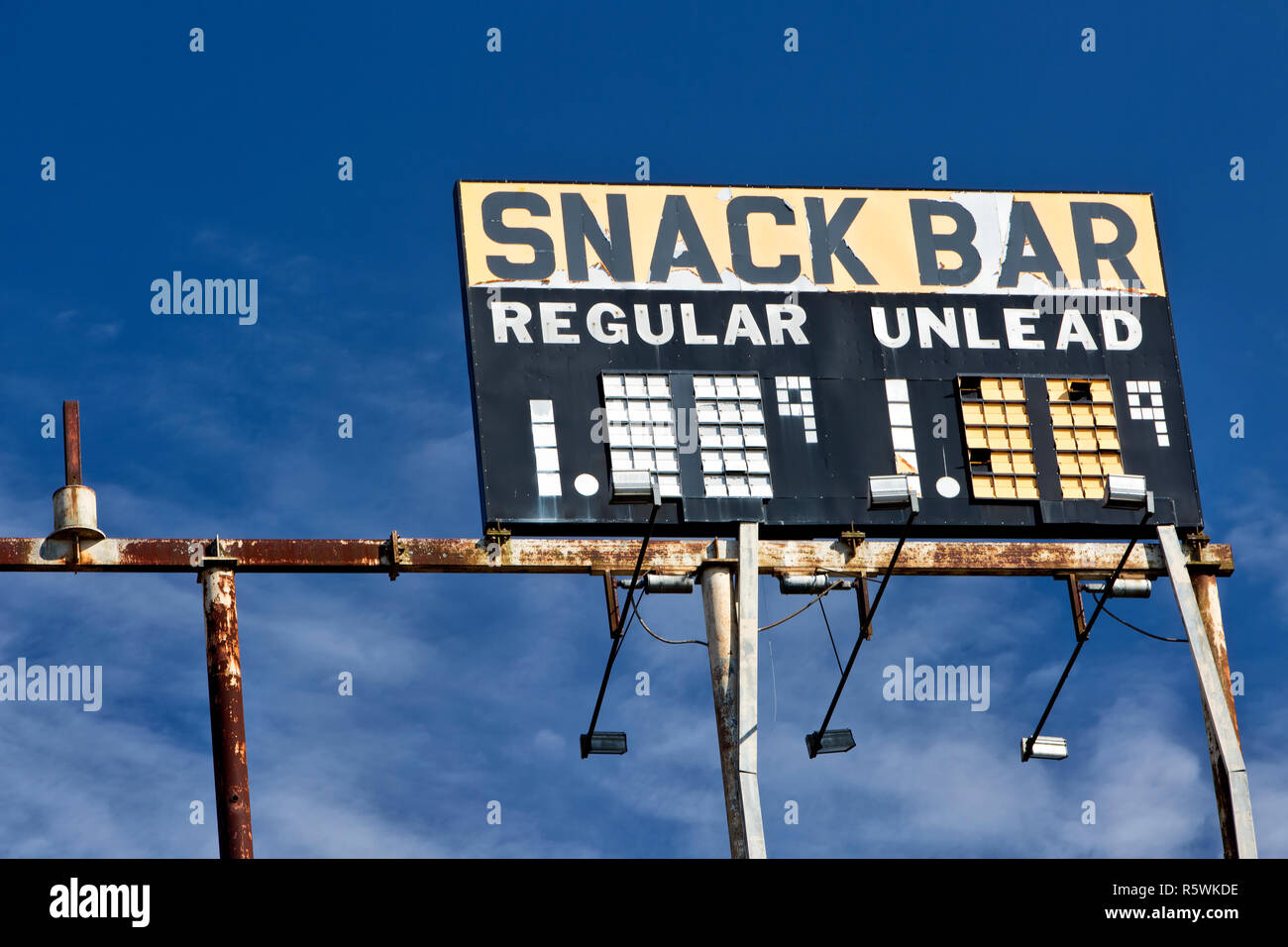 Elevata di Gas Vintage segno stazione "nack bar - Regolare - Unlead' BENZINA, contro un sparsi in cielo blu. Foto Stock