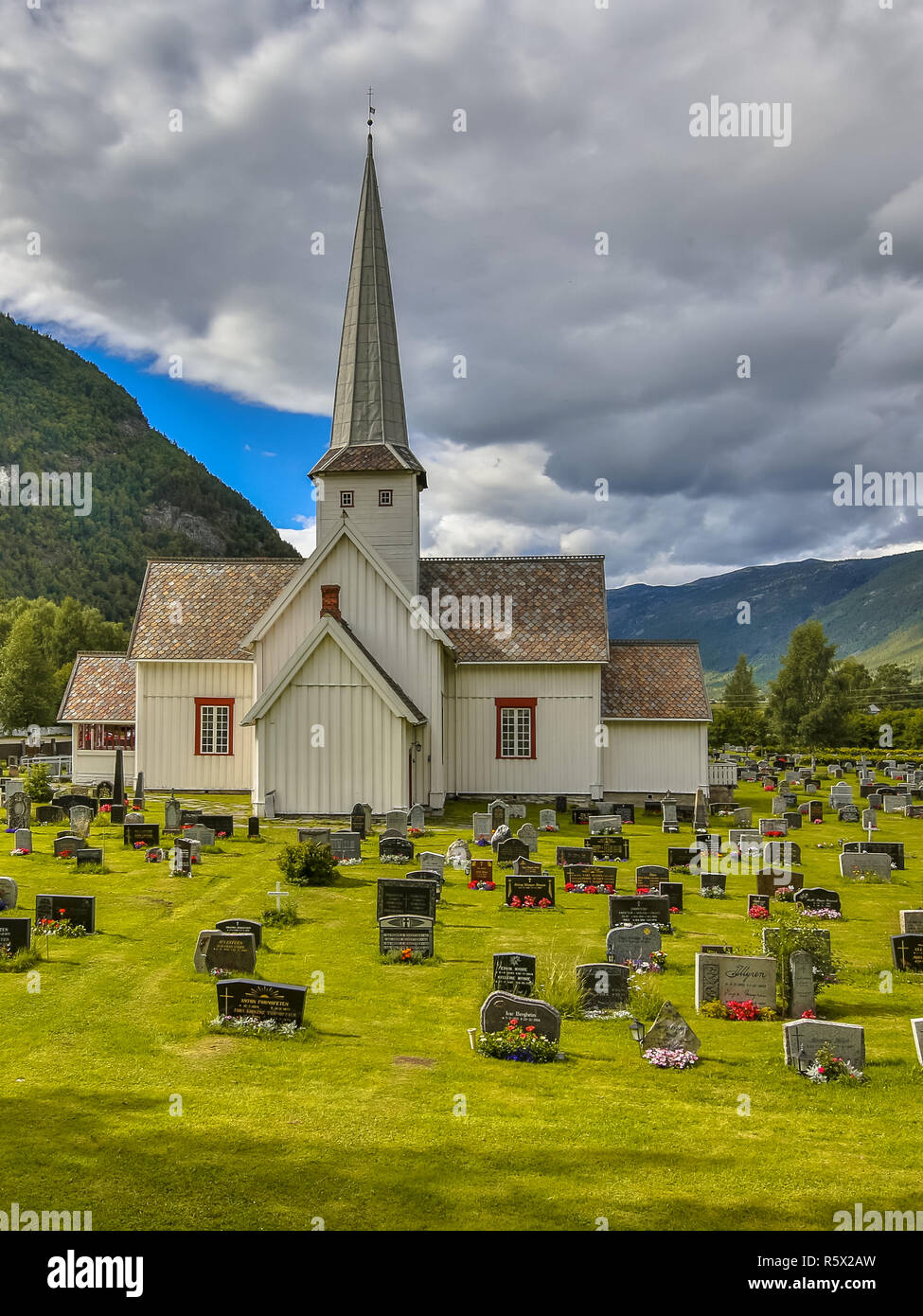 OPPLAND, Norvegia - 2 agosto 2016: Selsverket bianco tradizionale chiesa di legno con tombe e pietre Foto Stock