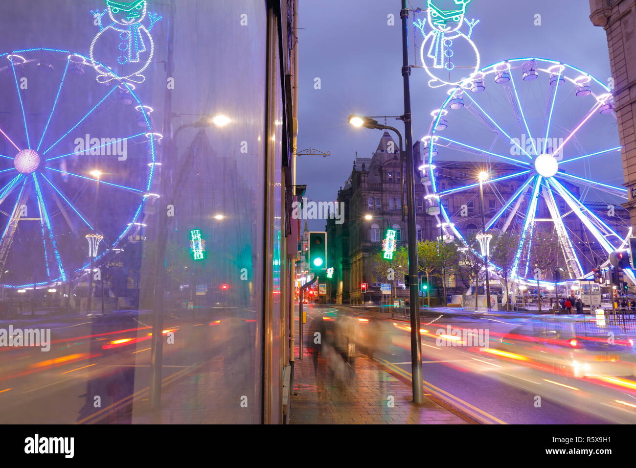 Riflessioni attraverso una finestra, della ruota grande attrazione turistica in Leeds City Centre di notte. Foto Stock