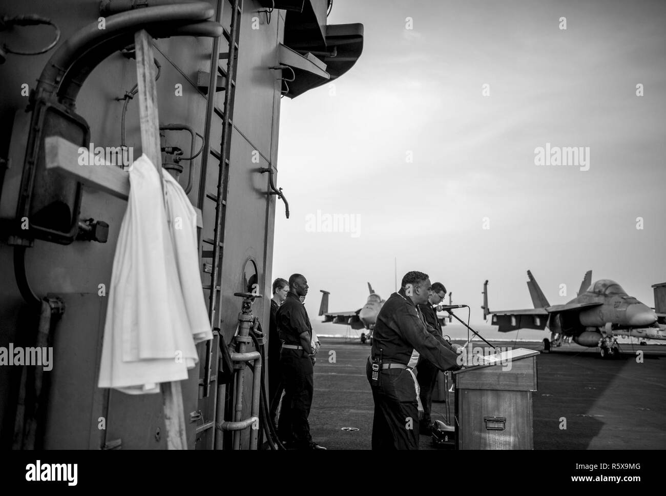 BAHRAIN (16 aprile 2017) della Cmdr. John Logan, un cappellano della Marina Militare a bordo della portaerei USS George H.W. Bussola (CVN 77) (GHWB), legge una preghiera durante un sunrise servizio Pasqua svoltasi sul ponte di volo. Il George H.W. Bush Carrier Strike gruppo è distribuito negli Stati Uniti Quinta Flotta area di operazioni a sostegno della sicurezza marittima operazioni destinate a rassicurare gli alleati e partner e preservare la libertà di navigazione un libero flusso di commercio nella regione. Foto Stock