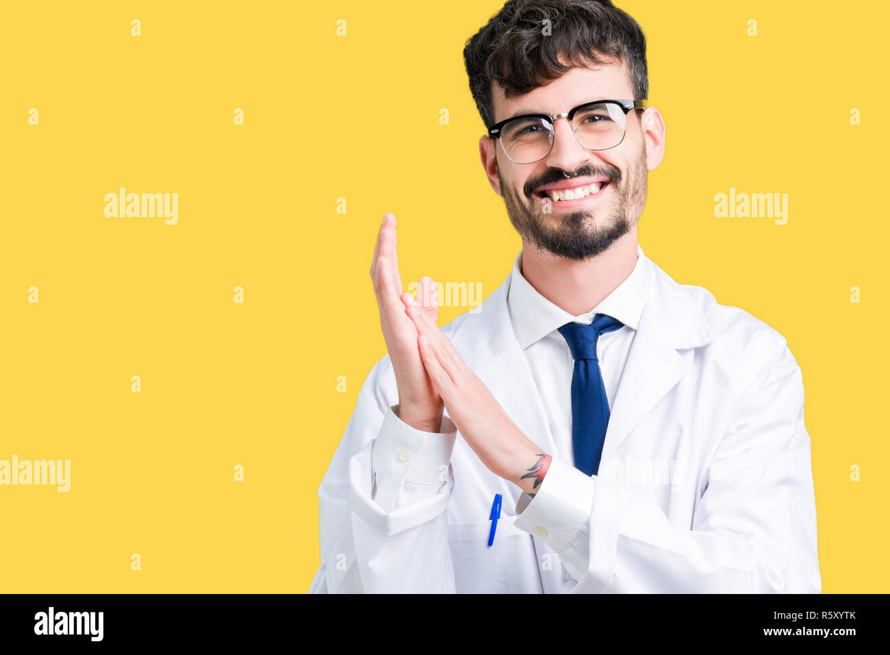 Giovani professionisti scienziato uomo che indossa mantello bianco su sfondo isolato battimani e applaudire felice e gioiosa, sorridente orgogliosi le mani insieme Foto Stock