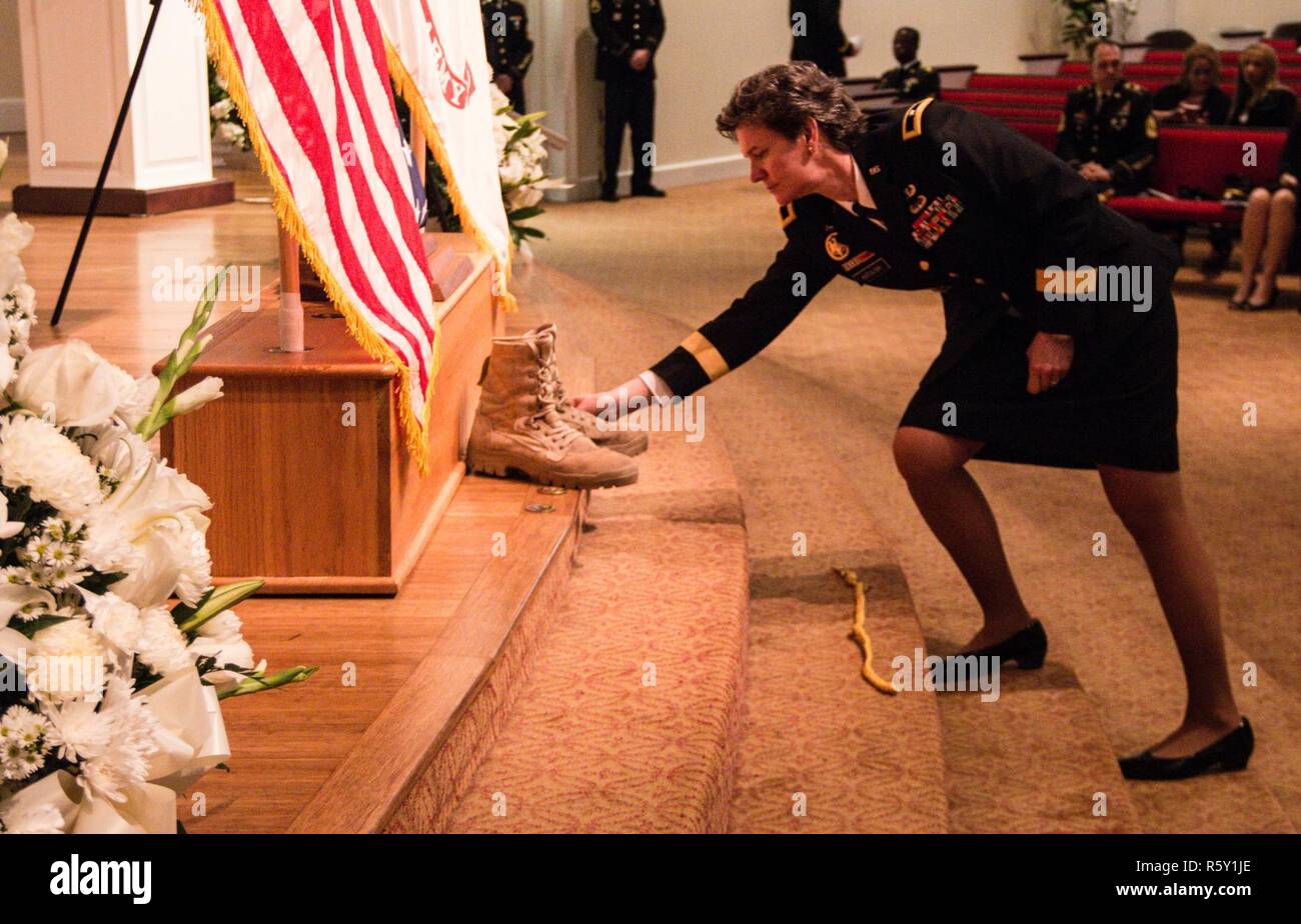 Esercito Brig. Gen. Deborah L. Kotulich, comandante generale, 143d supporto comando (Expeditionary), pone il suo comandante coin accanto a un paio di stivali dell'esercito una volta indossata da magg. Gen. Francisco A. Espaillat durante un memoriale di servizio 14 aprile 2017, in un primo momento Regno Chiesa Metodista di Oviedo, Fla. Espaillat, morto il 7 aprile è servito come il comandante generale della 143d dal CES 2014-2016 prima del trasferimento a Ft. E di Bragg accettando la sua assegnazione definitiva come il capo del personale per gli Stati Uniti La riserva di esercito di comando. Foto Stock