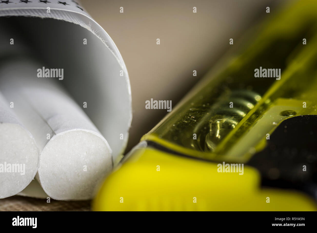 Sigarette e un accendino giallo vicino. Foto Stock
