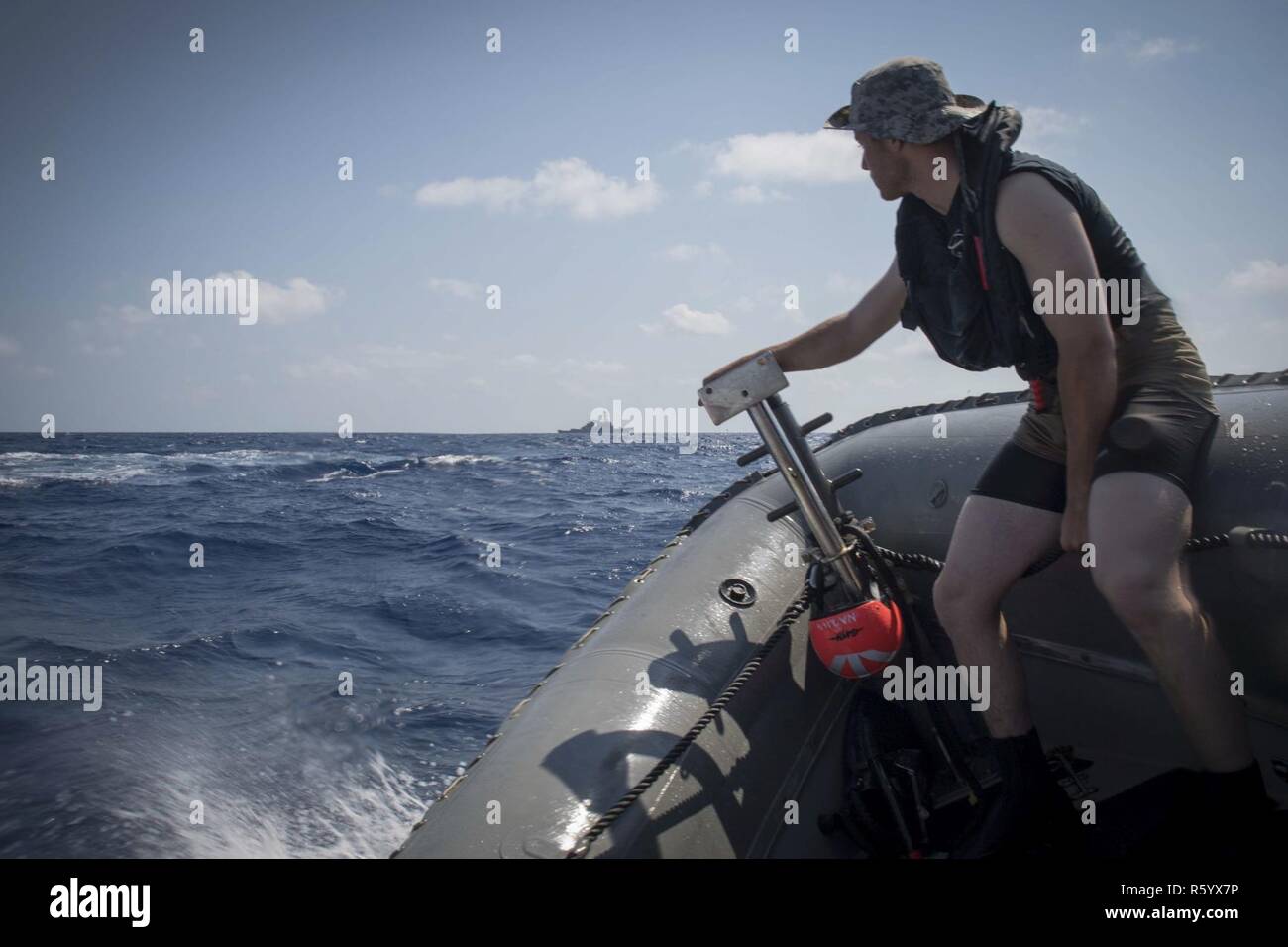 Sul mare del sud della Cina (13 aprile 2017) Airman Nusret Ahmetovic, assegnato per la ricerca e la squadra di salvataggio a bordo della Arleigh Burke-class guidato-missile destroyer USS Stethem (DDG 63), corse in una struttura rigida dello scafo di imbarcazione gonfiabile come l'equipaggio conduce piccole operazioni in barca nel Mare della Cina del Sud. Stethem è di pattuglia nel Mare della Cina del Sud il supporto di sicurezza e stabilità nella Indo-Asia-regione del Pacifico. Foto Stock