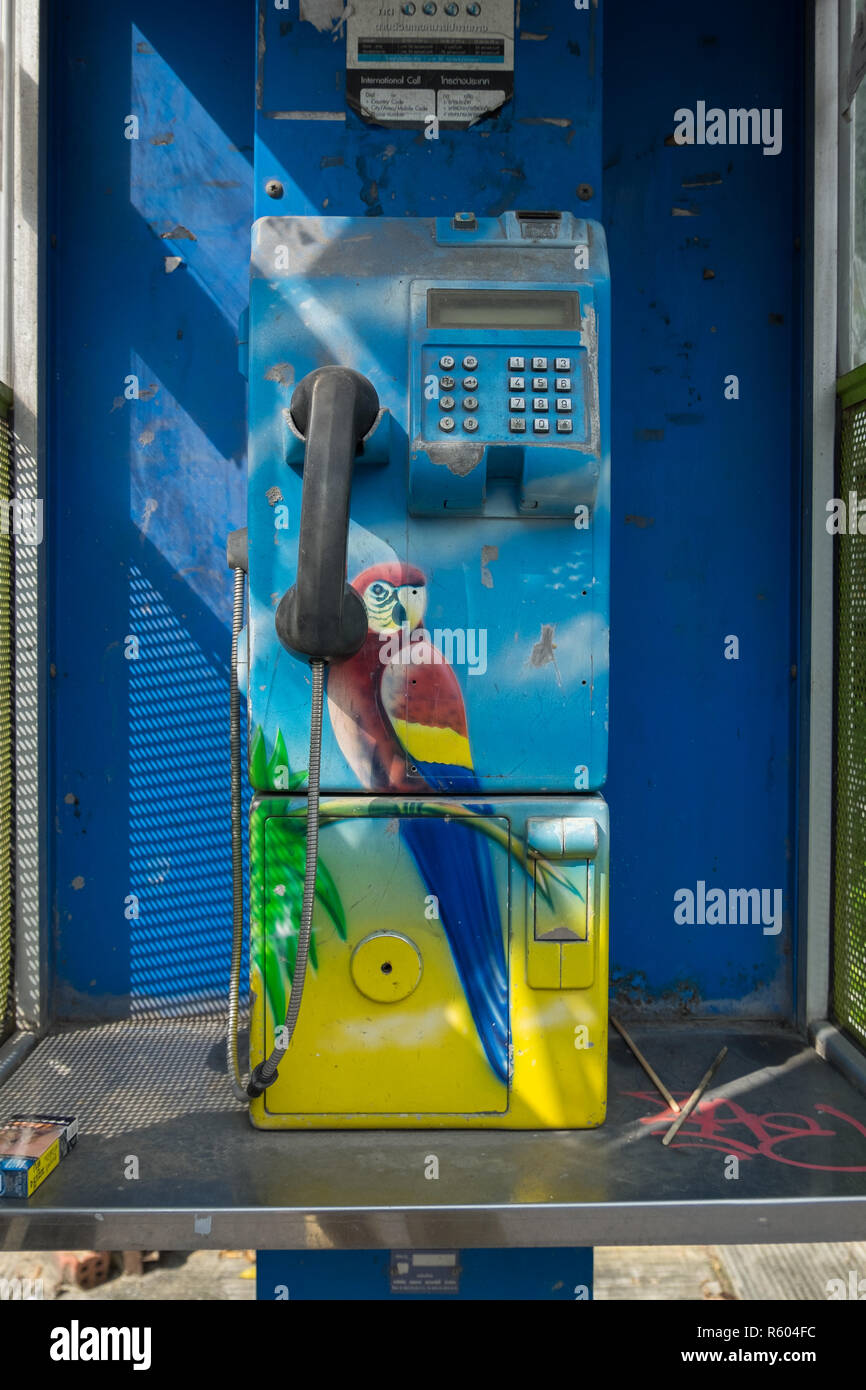 Un telefono a pagamento con un divertente tema tropicale che offre un pappagallo. In Hat Yai, Thailandia. Foto Stock