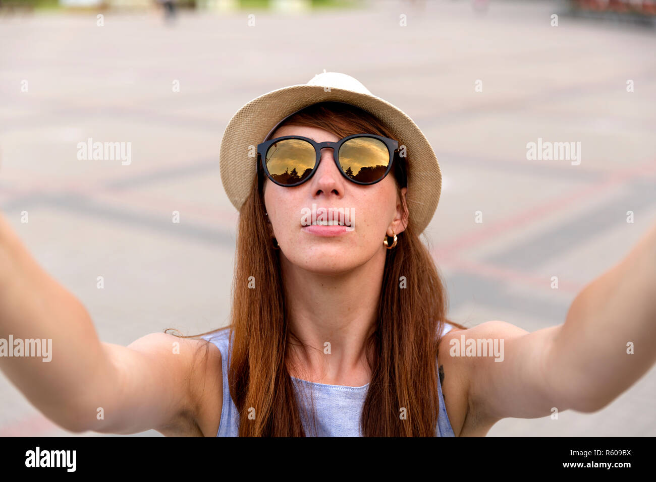 Piuttosto giovane turista prende selfie ritratto sulla piazza della città, Riga, Lettonia. Bella studentessa prende la foto per il blog di viaggio. Foto Stock