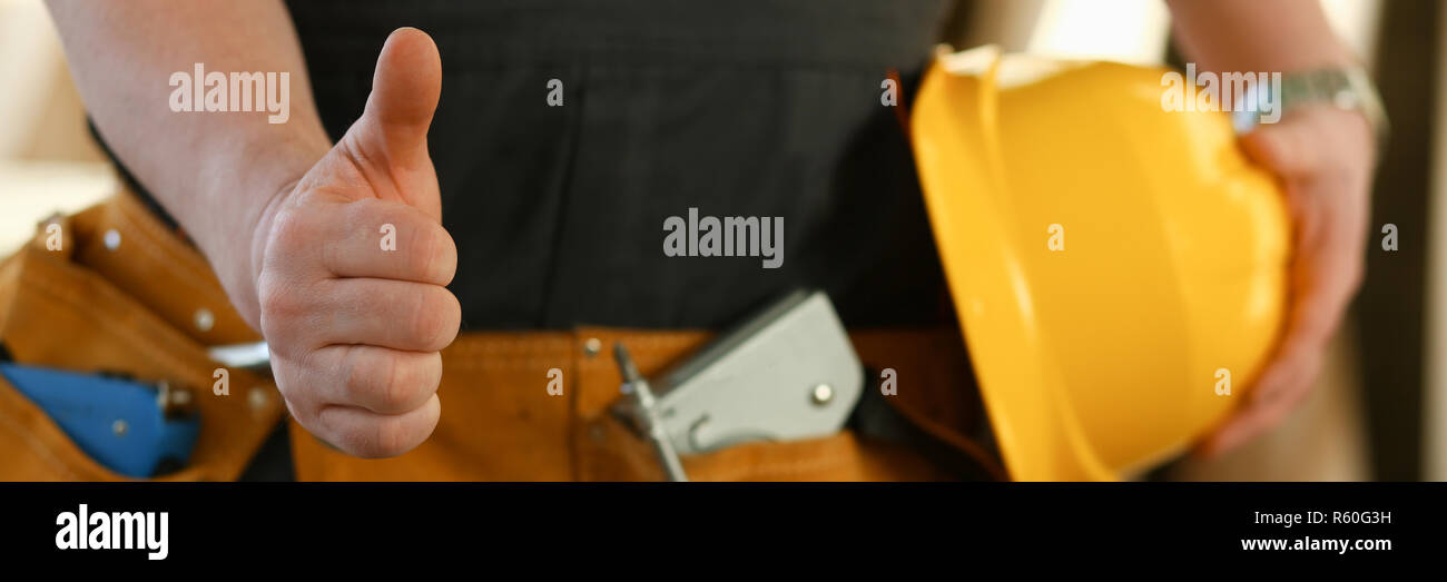 Mano del lavoratore nel casco giallo visualizza confermare Foto Stock