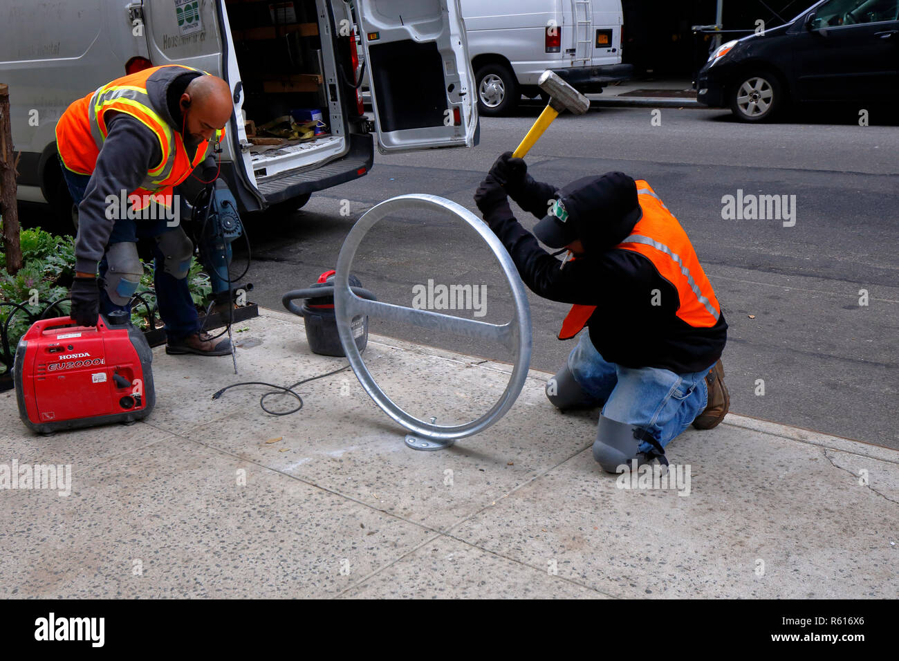 I lavoratori del Dipartimento dei Trasporti di New York installano un portabiciclette 'CityRack' su un marciapiede nel centro di Manhattan, New York, NY Foto Stock