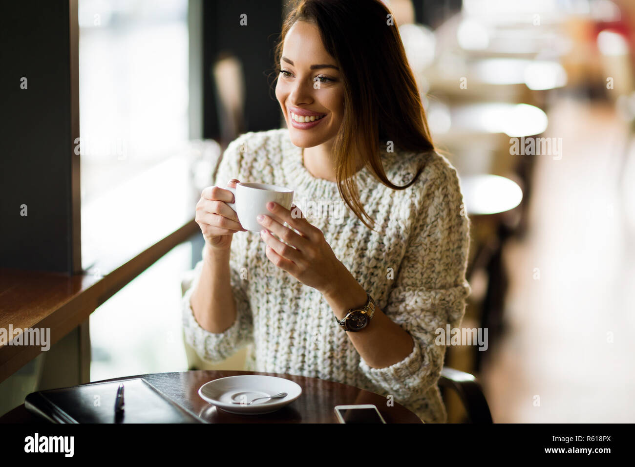 Ritratto di felice giovane donna in cafe Foto Stock