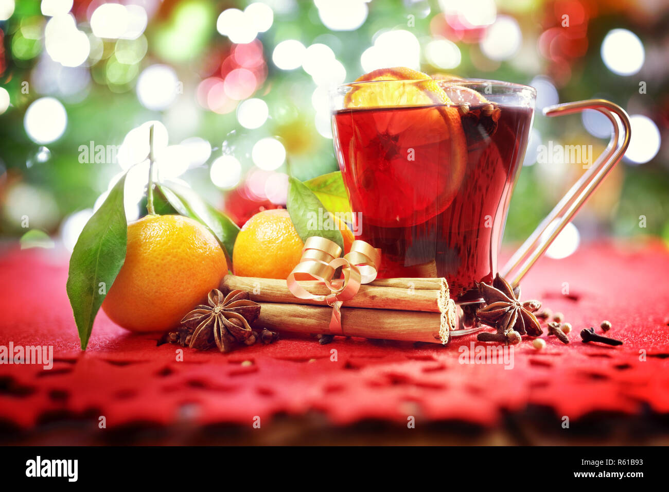 Sfondo di natale con vin brulé, arance, bastoncini di cannella nella parte anteriore della struttura ad albero Foto Stock