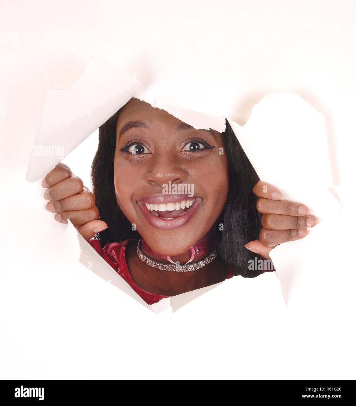 Donna sorridente guardando attraverso il foro Foto Stock