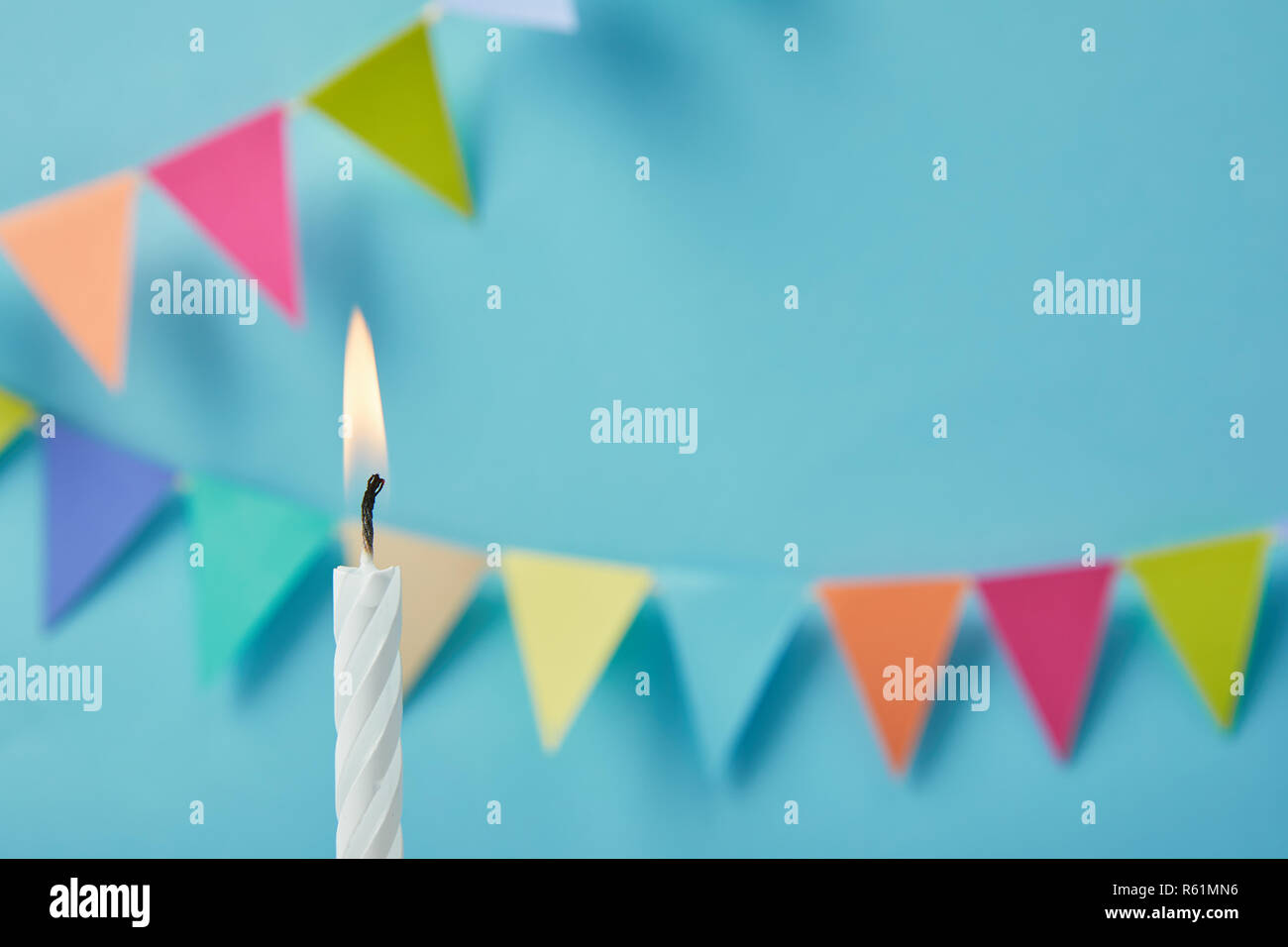 Candela su sfondo blu con bunting Foto Stock