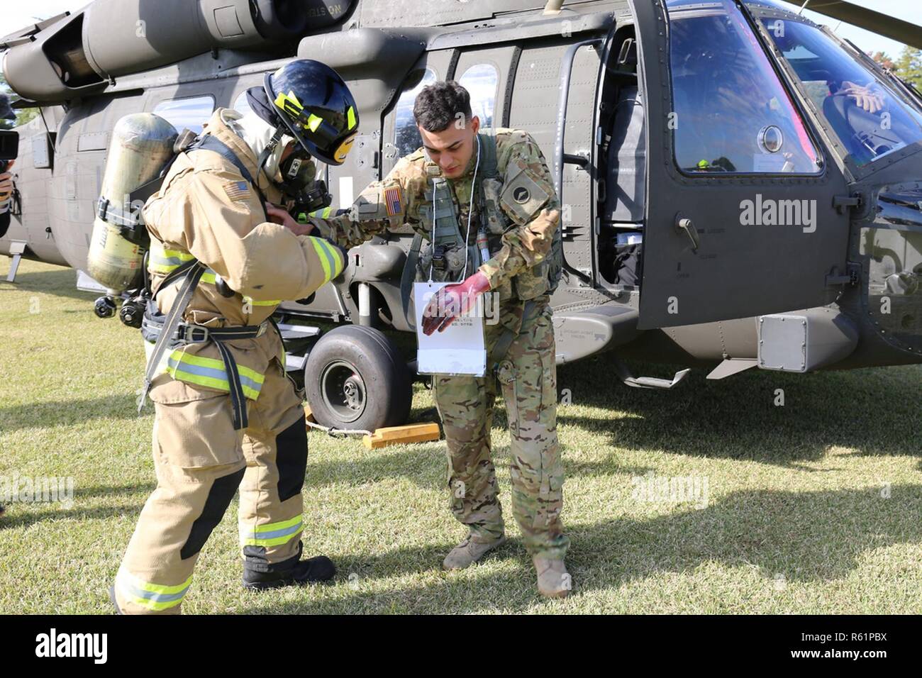 Shuichi Nakajima, U.S. Army Garrison Giappone pompiere, esamina "ferito" SPC. Jan C. LopezSoto, dalla U.S. Esercito Battaglione Aviazione Giappone, durante un UH-60 elicottero esercizio bilaterale nov. 16, 2018 a Sagami deposito generale, Giappone. La guarnigione e battaglione aviazione co-ospitato l'evento per migliorare la loro risposta in caso di emergenza e funzionalità di lavoro bilaterali con off-post first responder da Sagamihara città. Foto Stock