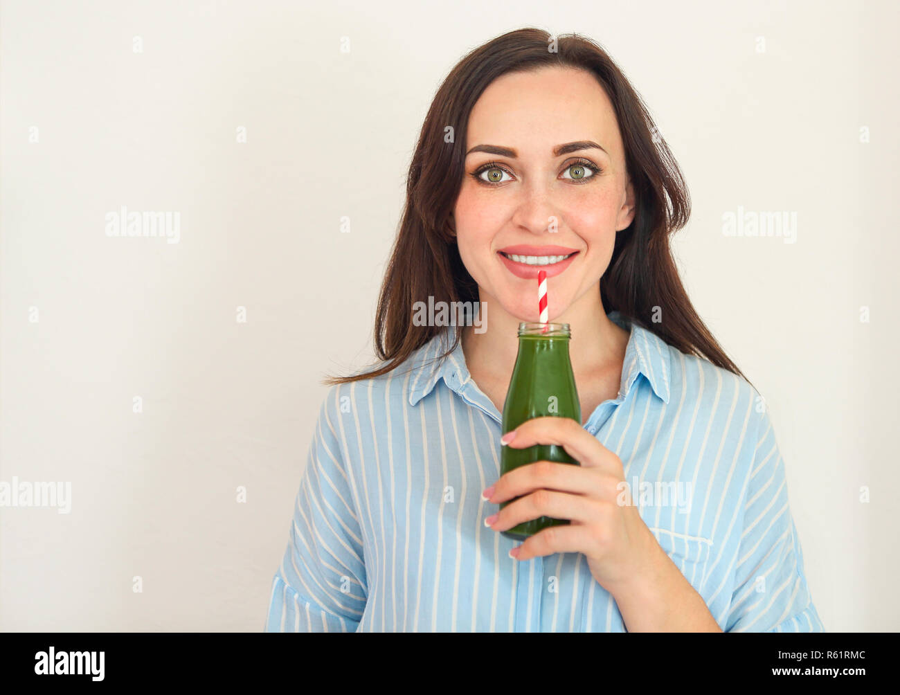 La dieta nutrizione con detox succo. Donna sana in posa con del succo di frutta fresco bottiglia di verde smoothie detox. Felice fit bella ragazza con del succo di frutta fresco Foto Stock