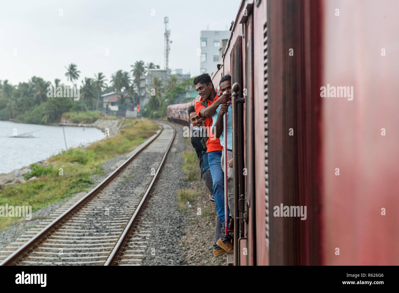 Persone aggrappati al treno di guida in Sri Lanka Foto Stock