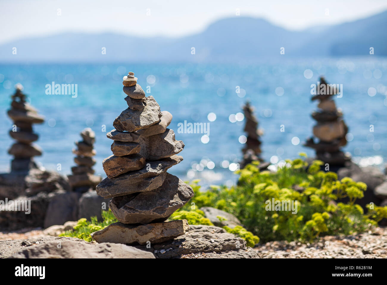 Equilibrio di pietre. Piramidi di pietre sulla spiaggia di ciottoli di Isola di Sardegna, Italia. Concetto di armonia Foto Stock