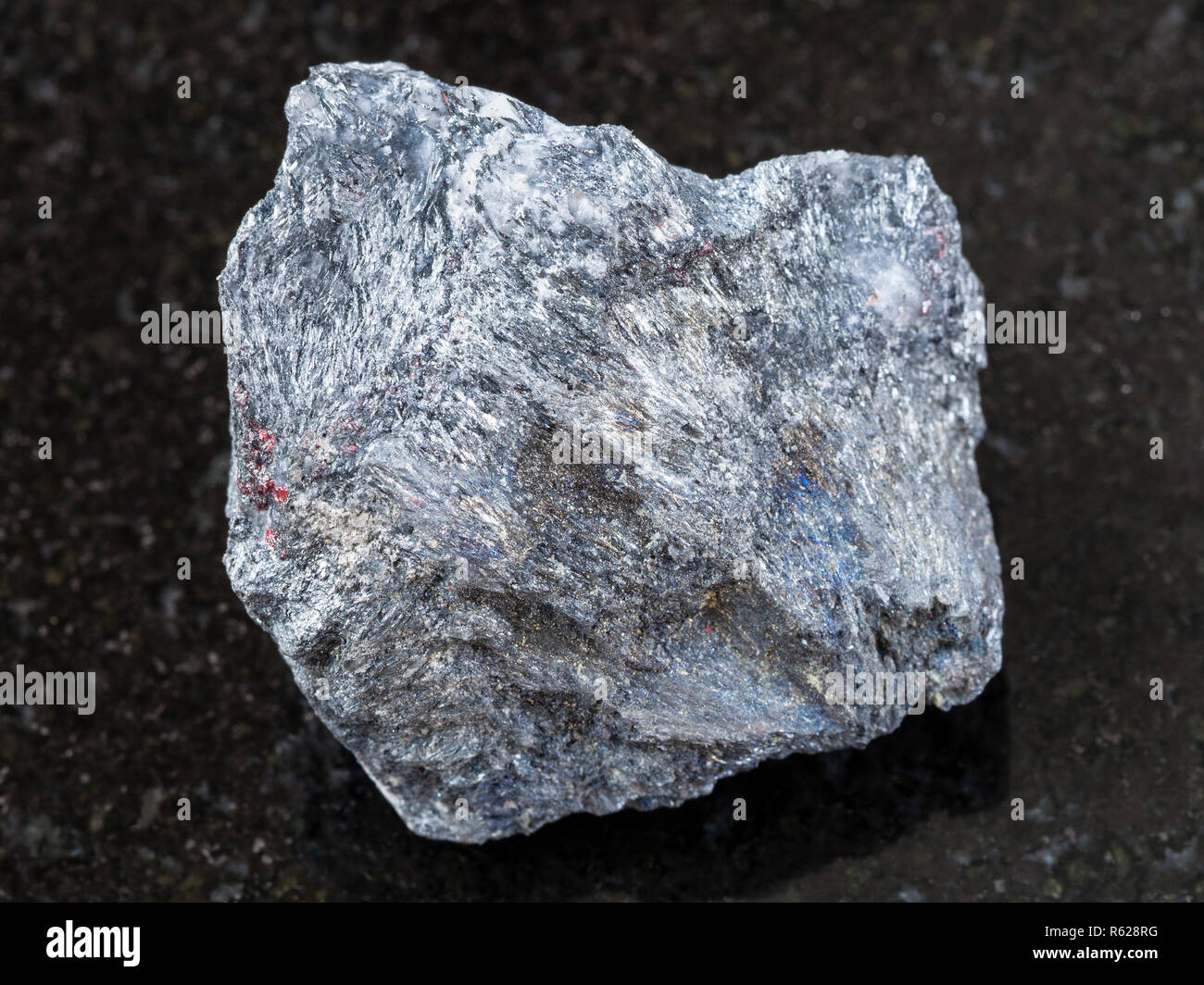 Ruvido minerale di antimonio (Stibnite) pietra sul buio Foto Stock