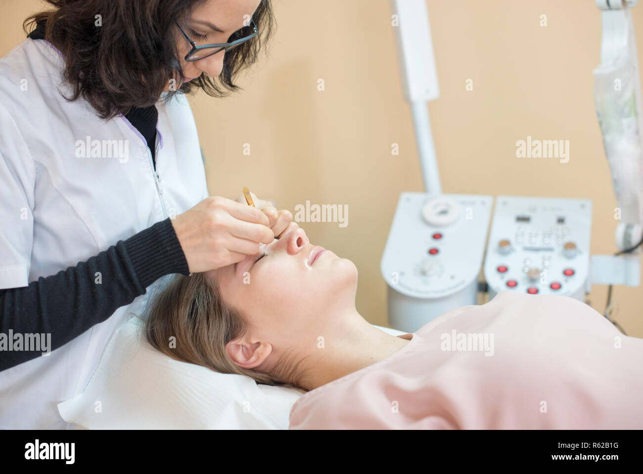 Donna presso il salone professionale per la correzione delle sopracciglia Foto Stock