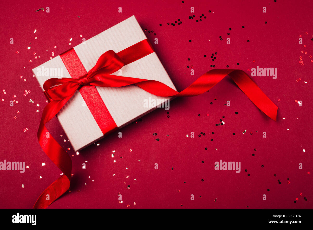 Craft Confezione Regalo Con Fiocco Rosso Fesrive Su Sfondo Rosso Con Bagliori Foto Stock Alamy