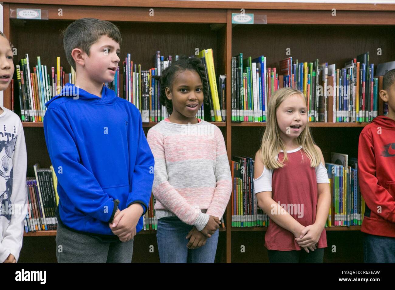 Gli studenti di Creekside Scuola Elementare cantare a Marines con ala Marine Headquarters Squadron (MWHS) 2 in New Bern, North Carolina, nov. 16, 2018. MWHS-2 ha visitato la scuola di rinnovare il loro adottare un partenariato scolastico e visitare gli studenti. Foto Stock