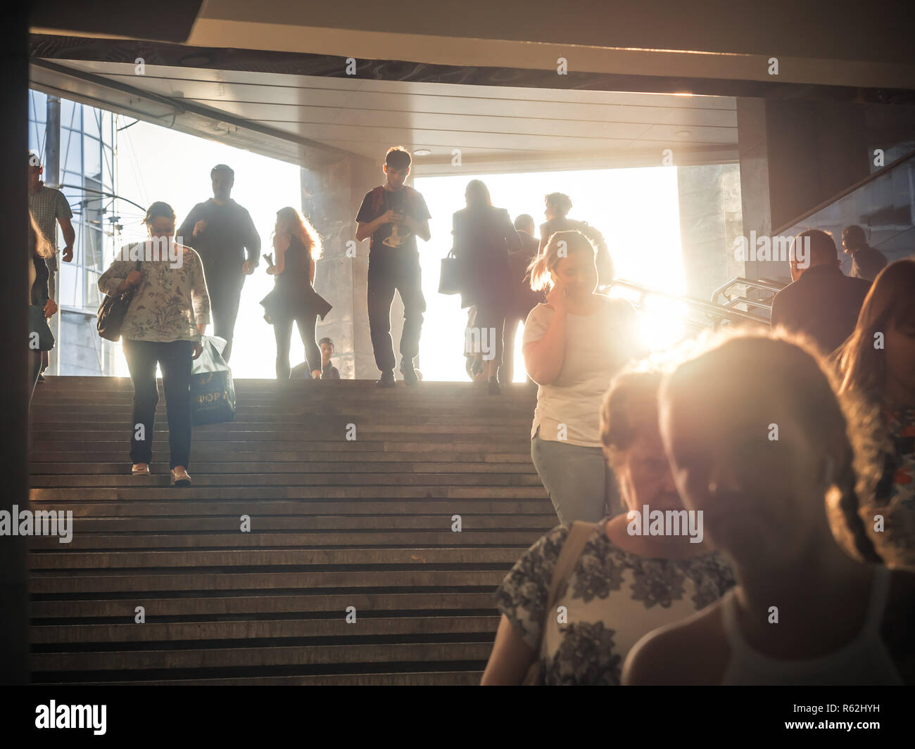 Mosca, Russia - 6 Settembre 2018: la gente comune Vai Su e Vai Giù per la metropolitana in ora di punta. Popolo di andare giù per il sottopassaggio. Sagome di persone che camminano giù i passaggi sullo sfondo della sun. Foto Stock