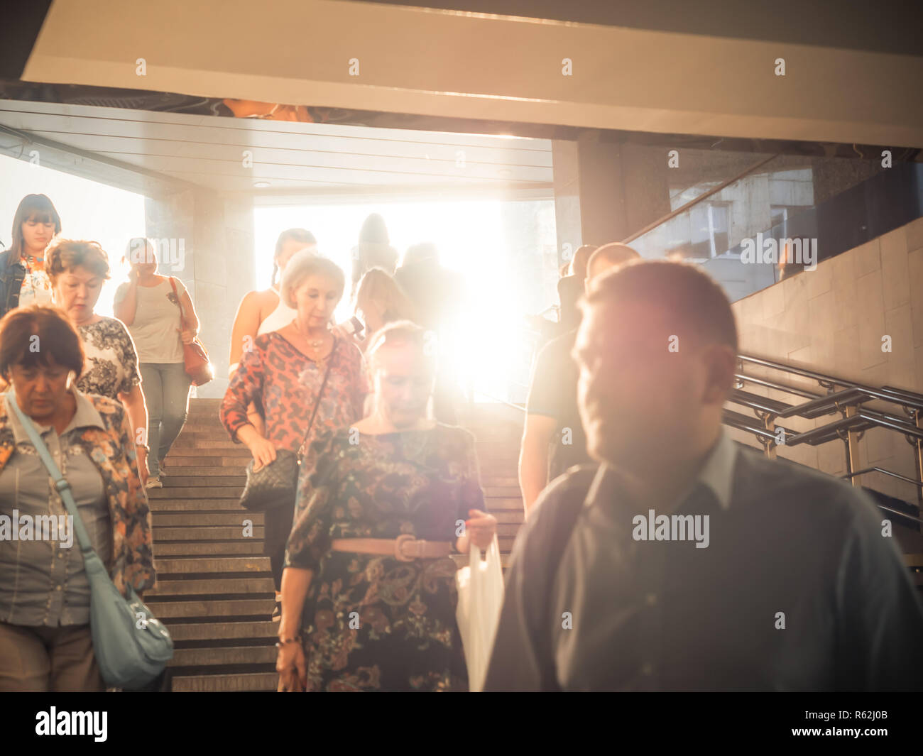 Mosca, Russia - 6 Settembre 2018: la gente comune Vai Su e Vai Giù per la metropolitana in ora di punta. Popolo di andare giù per il sottopassaggio. Sagome di persone che camminano giù i passaggi sullo sfondo della sun. Foto Stock