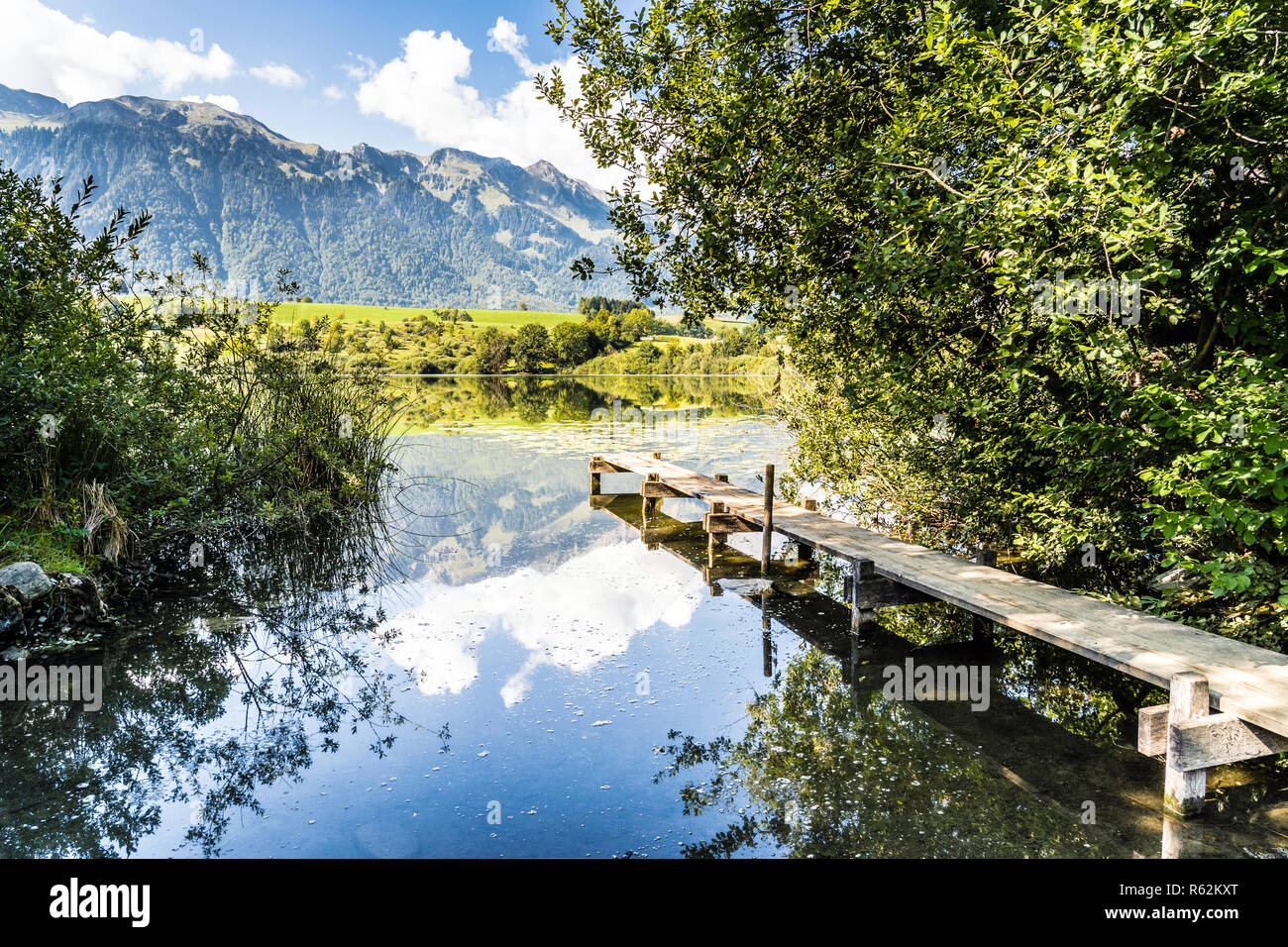 Lago di montagna nella amsoldingen, pacifica con passerella e vista del Berner Alpi, Svizzera Foto Stock