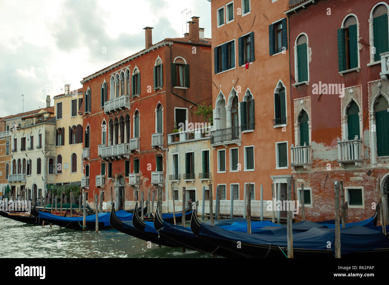 Colpo lungo degli edifici lungo un canale veneziano, con gondole ancorate nella parte anteriore Foto Stock