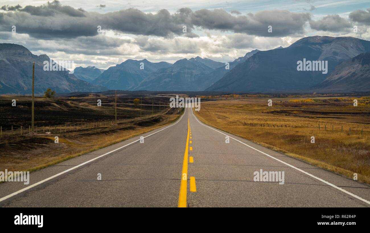 Autostrada verso il Parco Nazionale di graffiato, bruciata su un lato da incendi Foto Stock