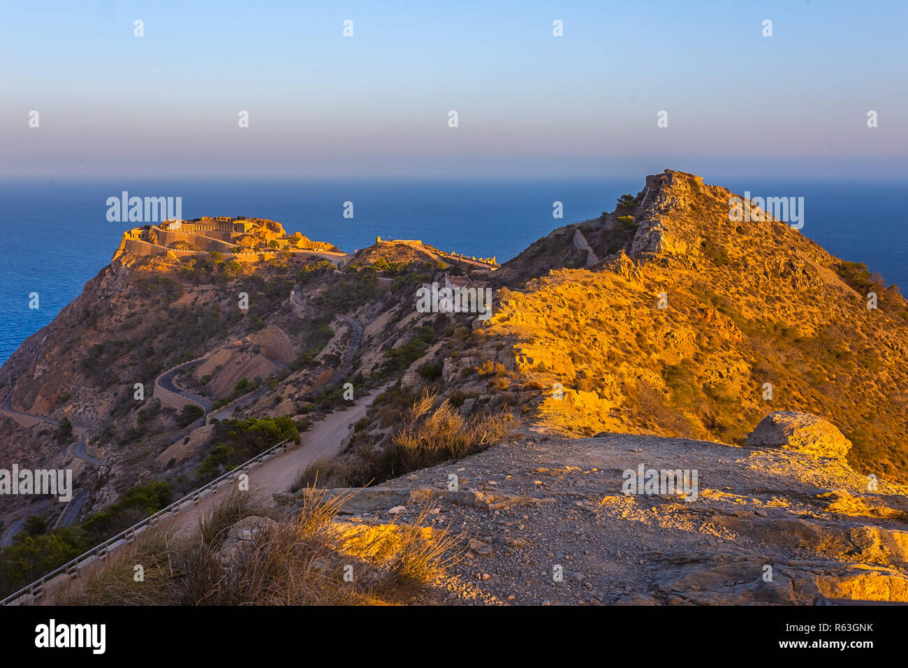 Patrimonio vuoto insolito luogo famoso Castillitos batteria, antico punto di riferimento sulla costa del Mar Mediterraneo, fortificazione, muro fortificato della città di Cartagena, Murcia. Scenario idilliaco e montagne. Spagna Foto Stock