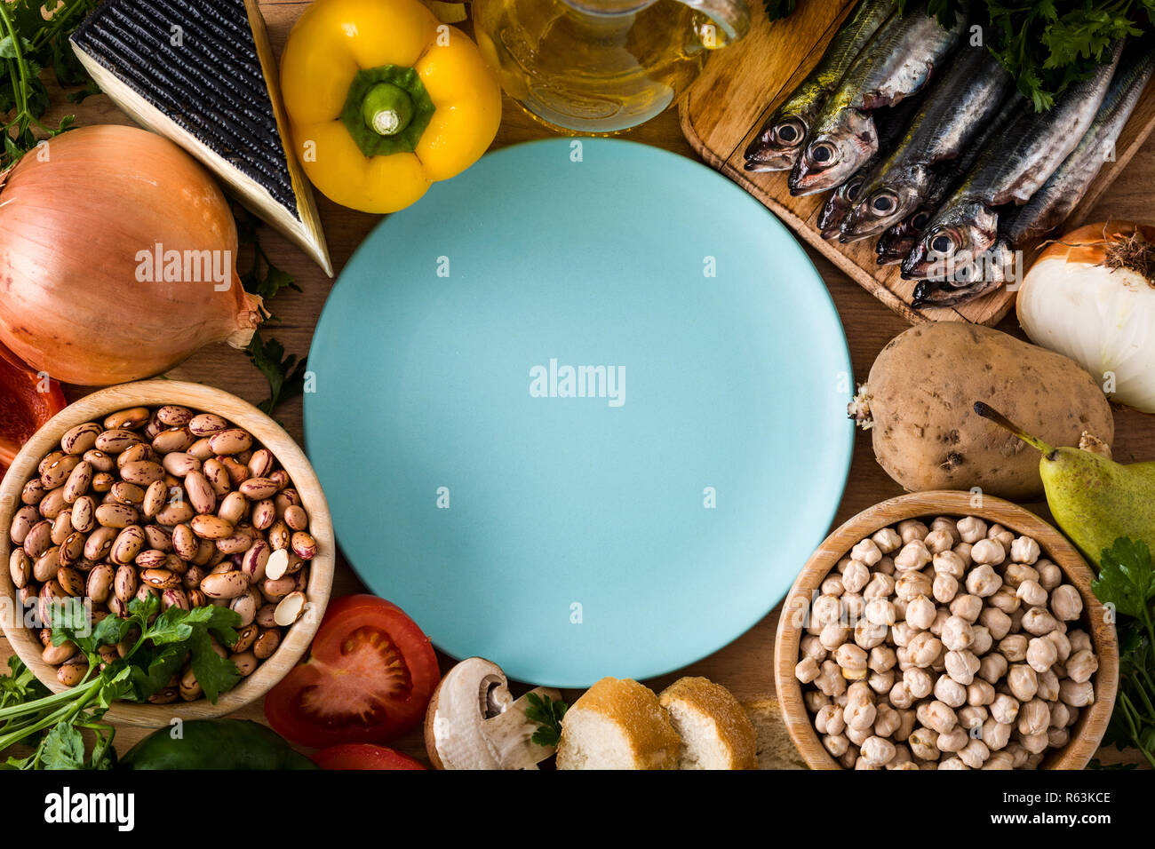 Mangiare sano. Dieta mediterranea. Frutta, verdura, cereali, noci olio d'oliva e il pesce su un tavolo di legno. Vista da sopra con copia spazio sulla piastra Foto Stock