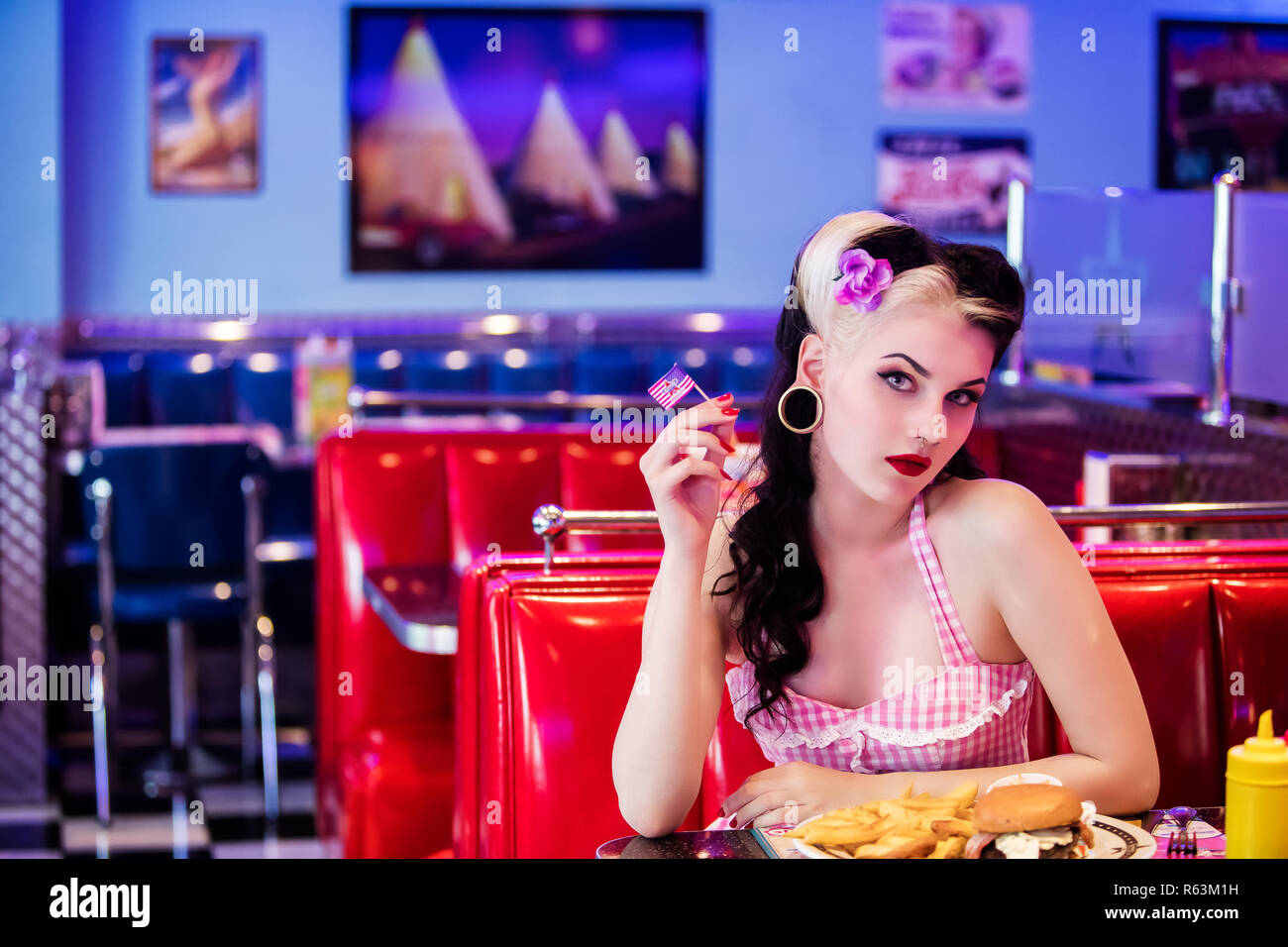Ritratto di un giovane Pin Up, volto in profilo, tenendo una piccola bandiera americana Foto Stock