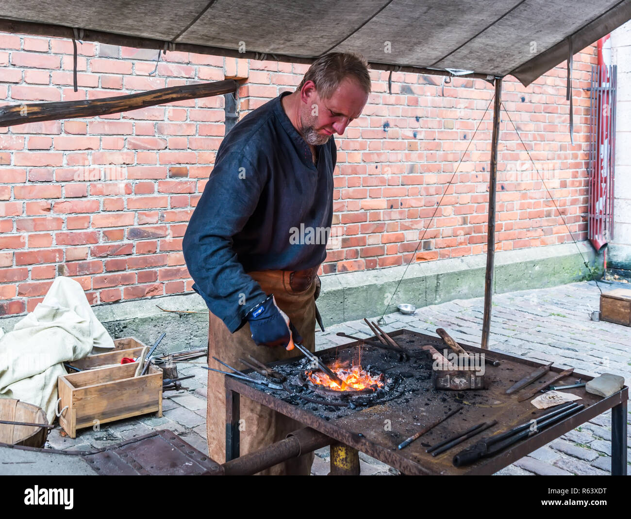Riga, Lettonia - 18 agosto 2018: fabbro lavora al medievale mercato di artigianato durante la città di Riga Festival. Foto Stock