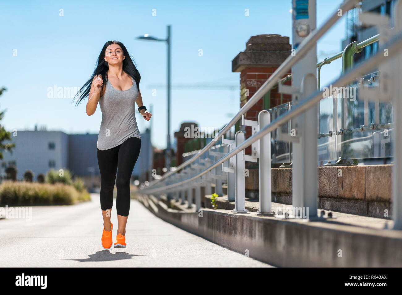 Città allenamento. Bella donna in esecuzione in ambiente urbano Foto Stock