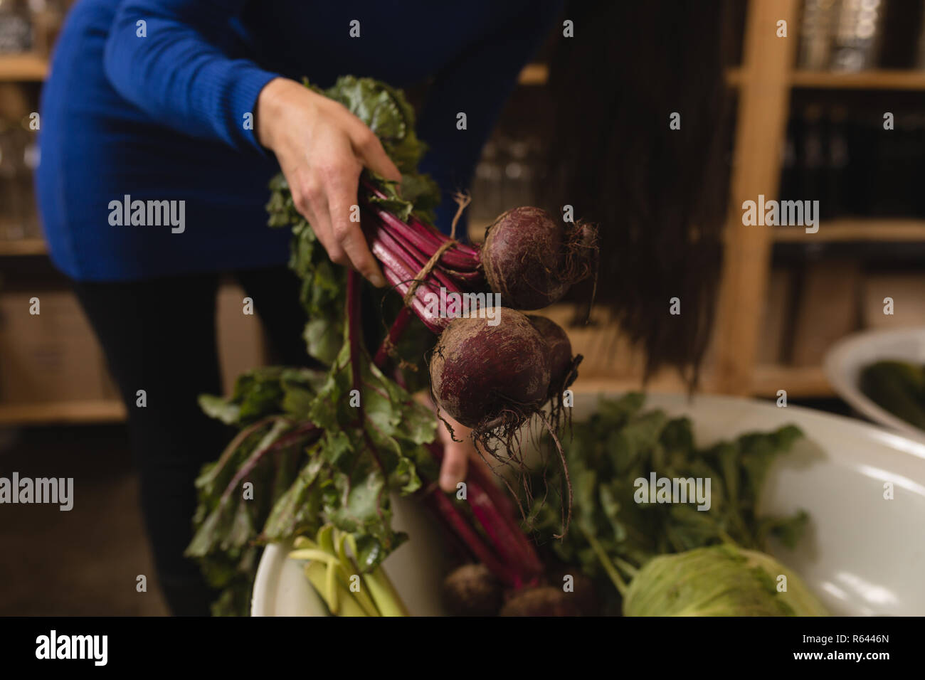 Donna vegetale di prelievo dal cestello nel supermercato Foto Stock
