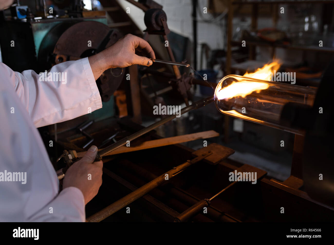 Lavoratore utilizzando la torcia di saldatura in fabbrica del vetro Foto Stock