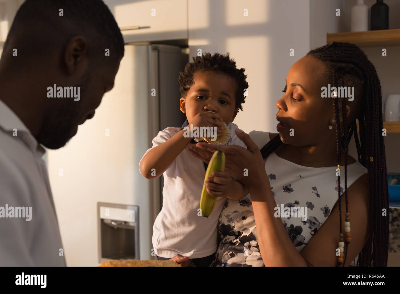 Madre di alimentazione per alimentare il suo figlio in cucina Foto Stock