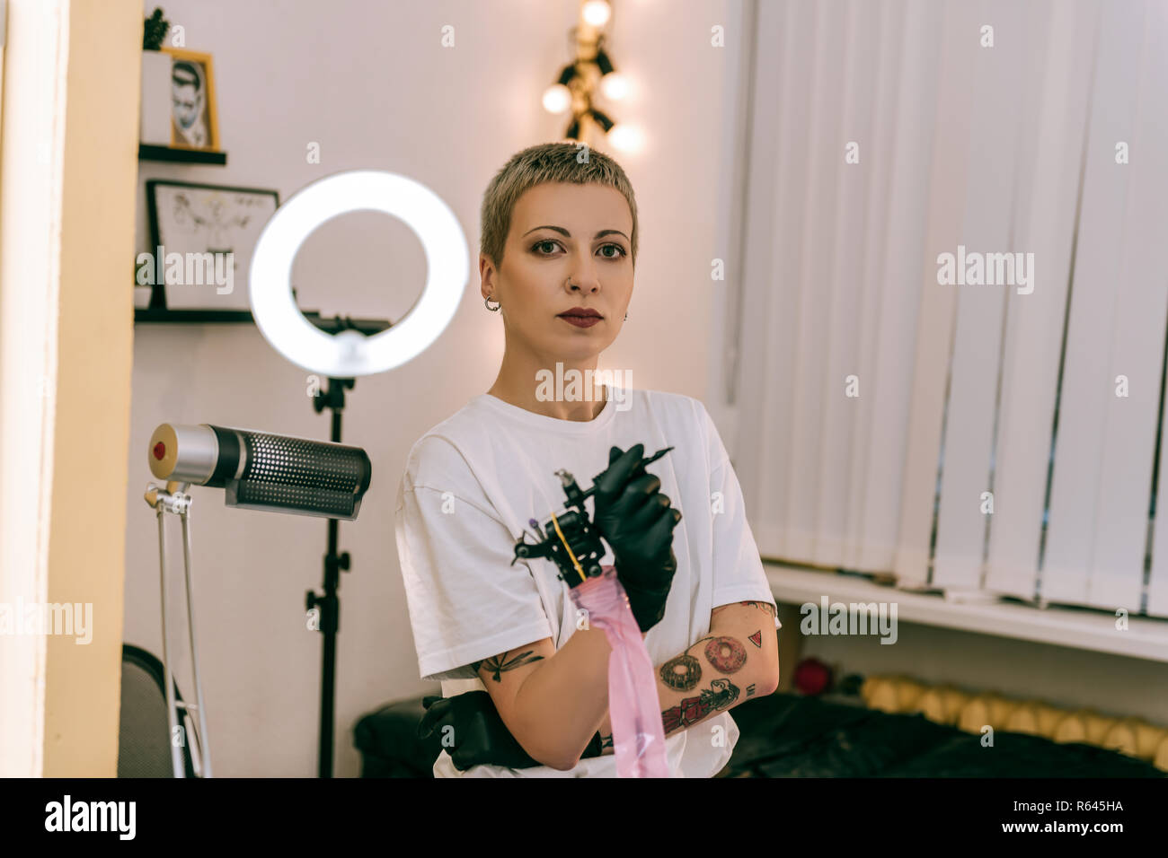 Fanciullesco femmina porta master tattoo machine nelle sue mani Foto Stock