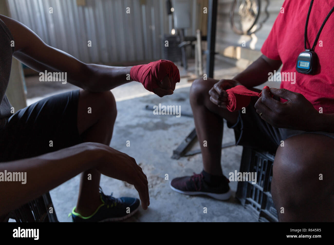 Il Trainer assiste boxer maschio in legatura legatura a mano a portata di mano Foto Stock