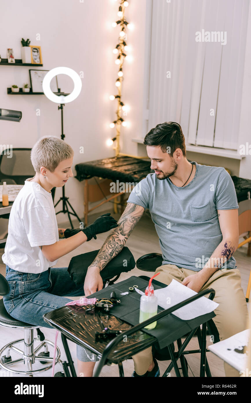 A pelo corto donna bionda lavora con manicotto di tatuaggio Foto Stock